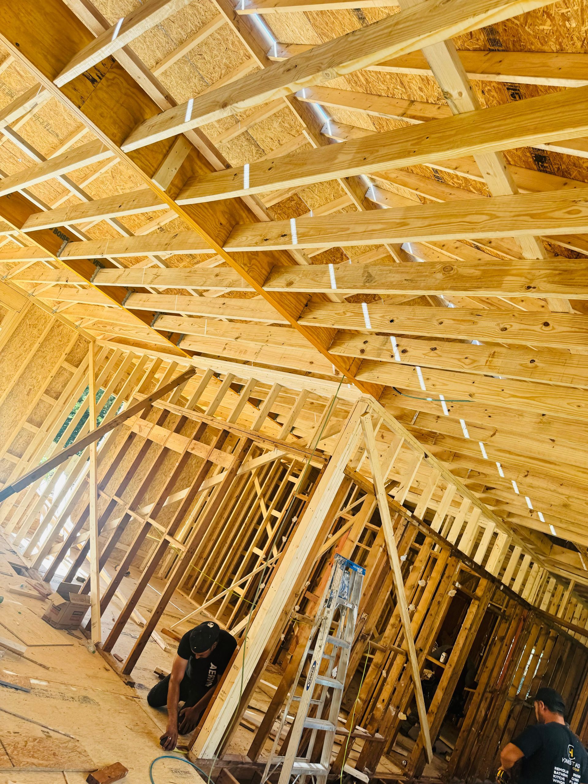 A man is working on the ceiling of a house under construction.