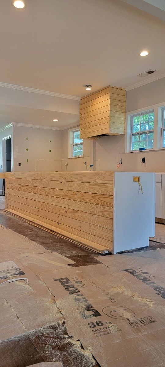 A kitchen in a house under construction with a wooden counter top.