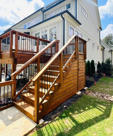 A house with a wooden deck and stairs leading up to it.