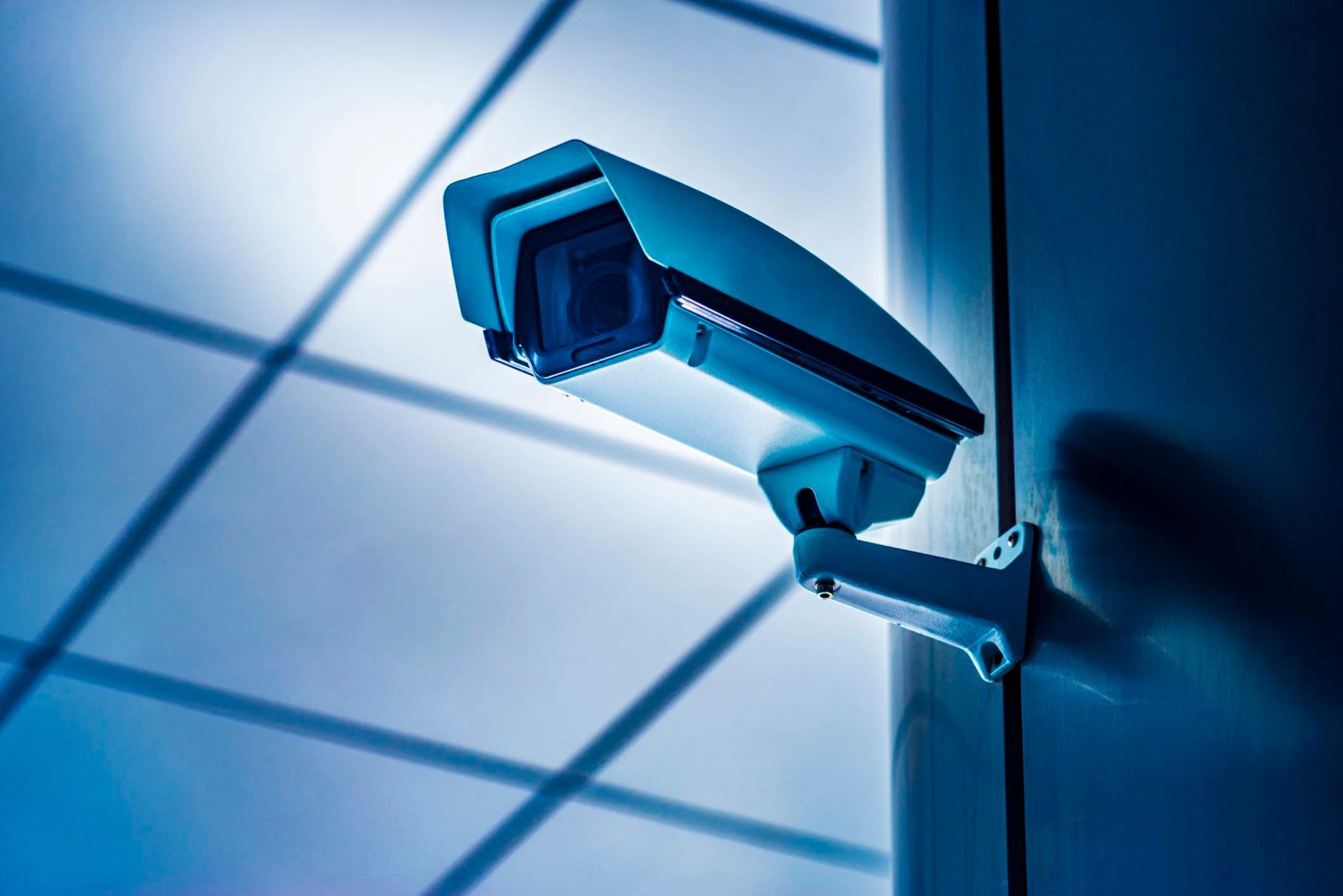 A security camera is mounted on a pole in a room