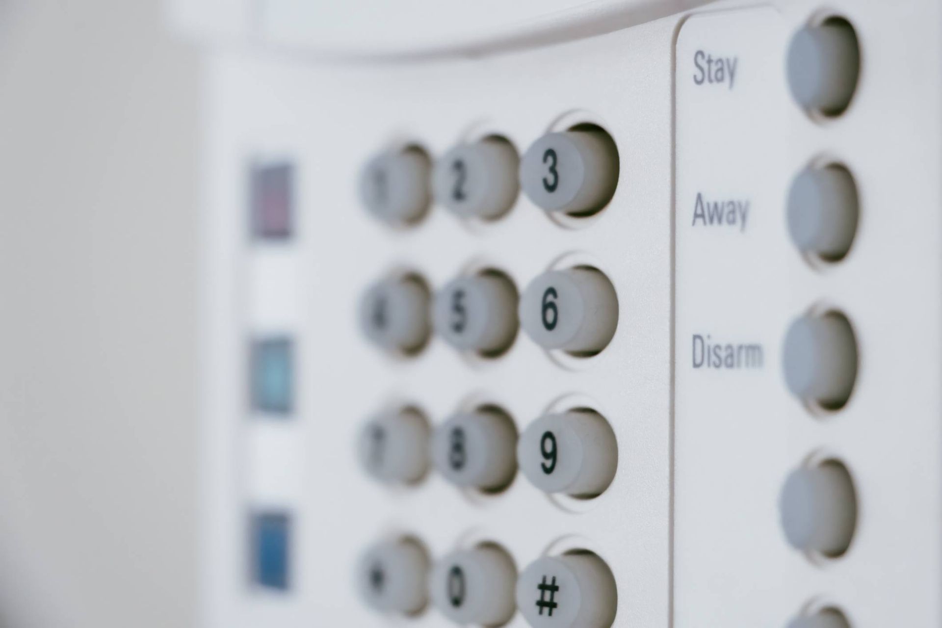 A close up of a security system with buttons for stay away and disarm