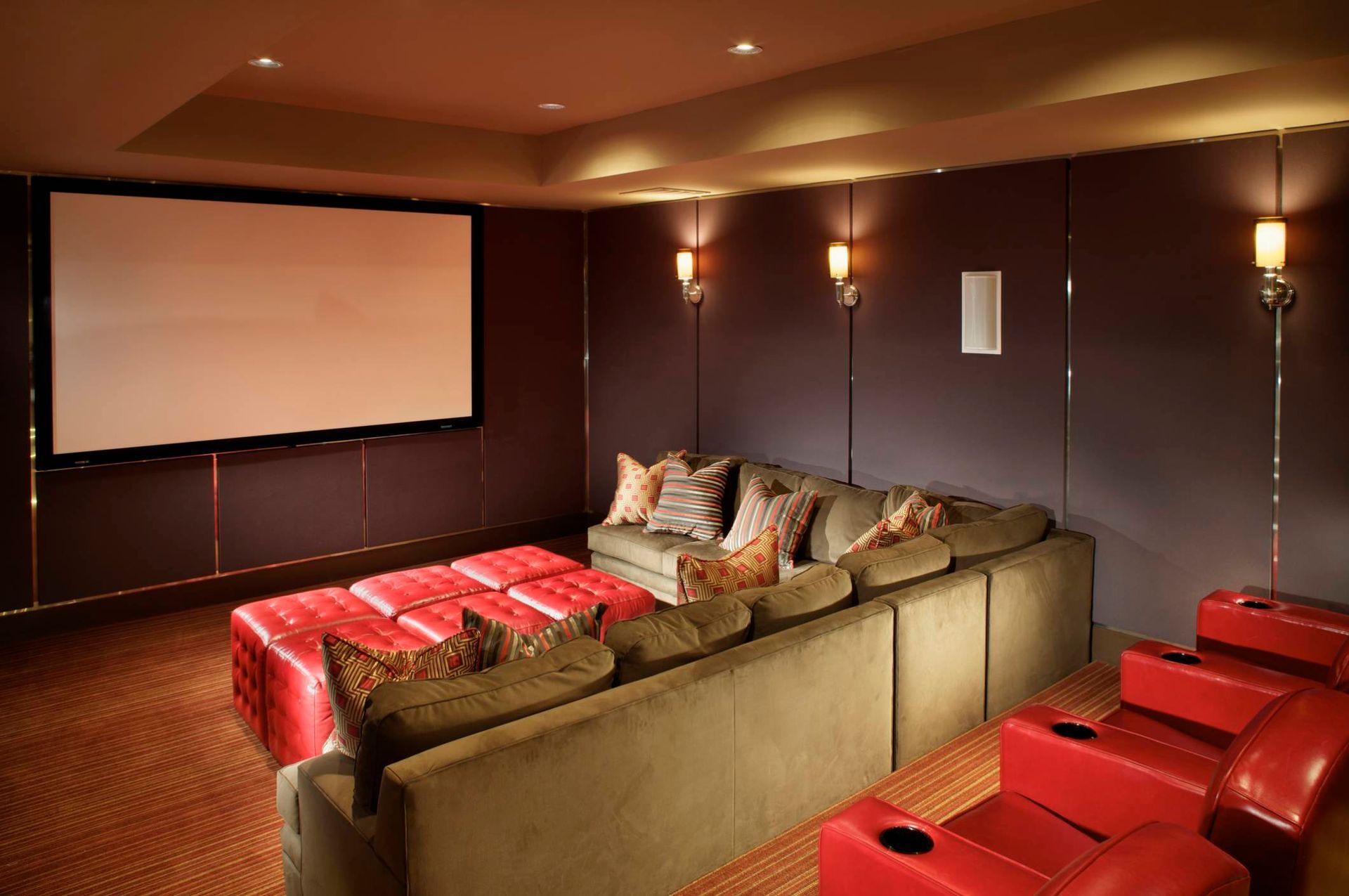 A home theater with a couch and chairs and a large screen