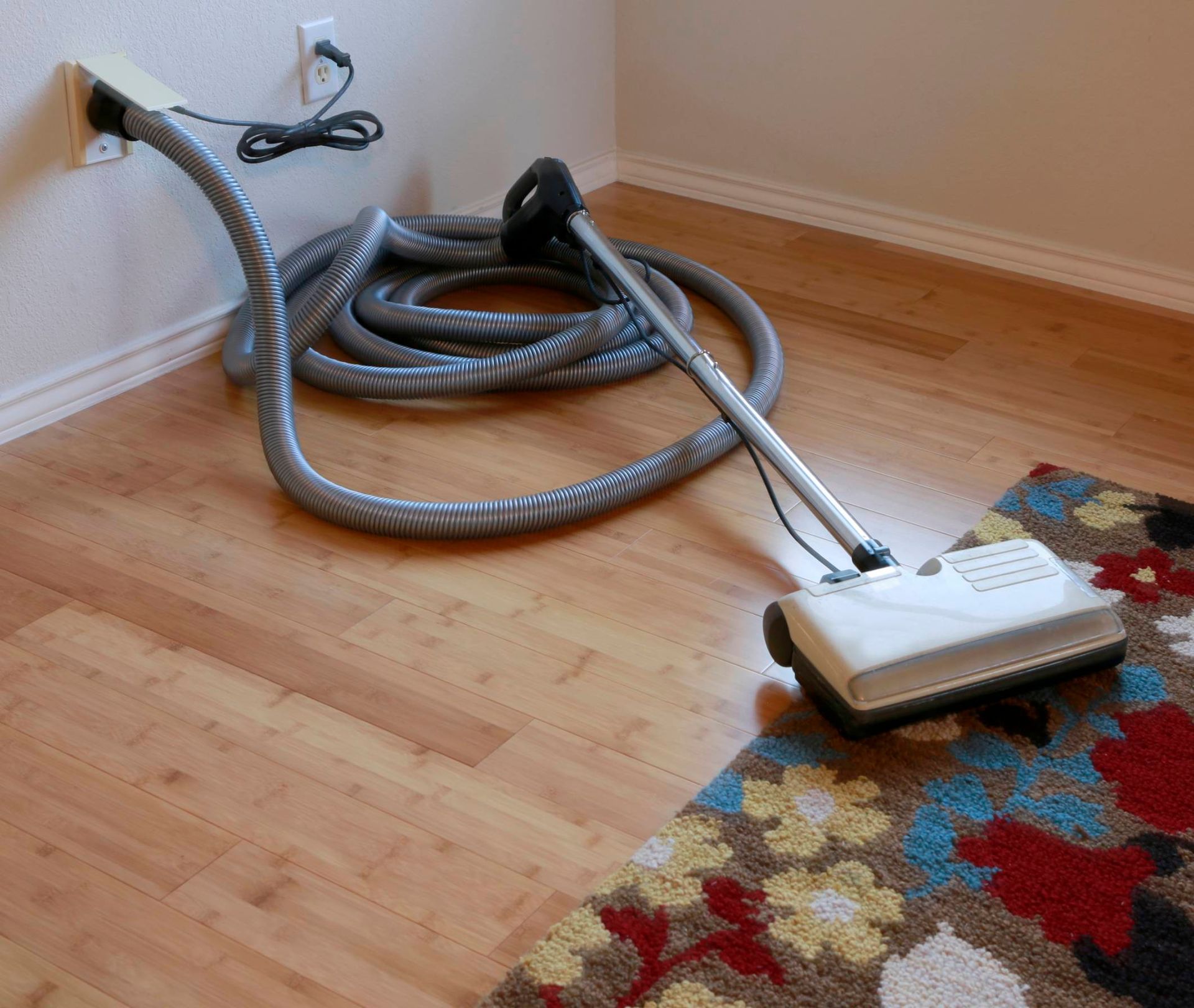 A vacuum cleaner is sitting on the floor next to a rug