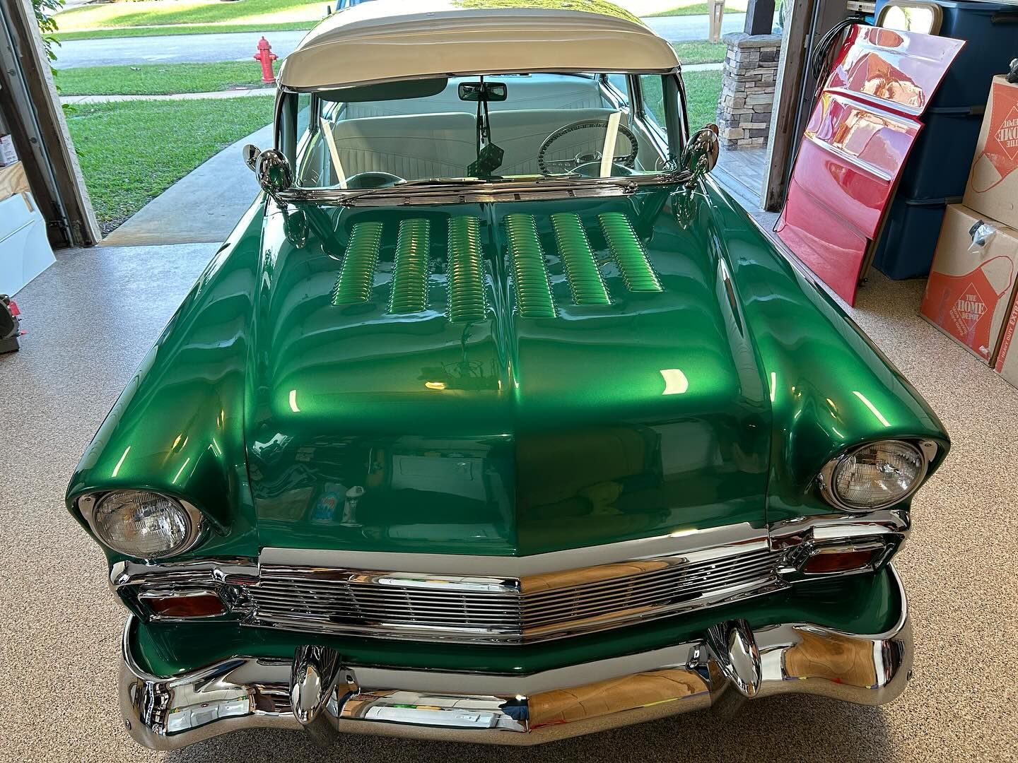 A green car is parked in a garage.