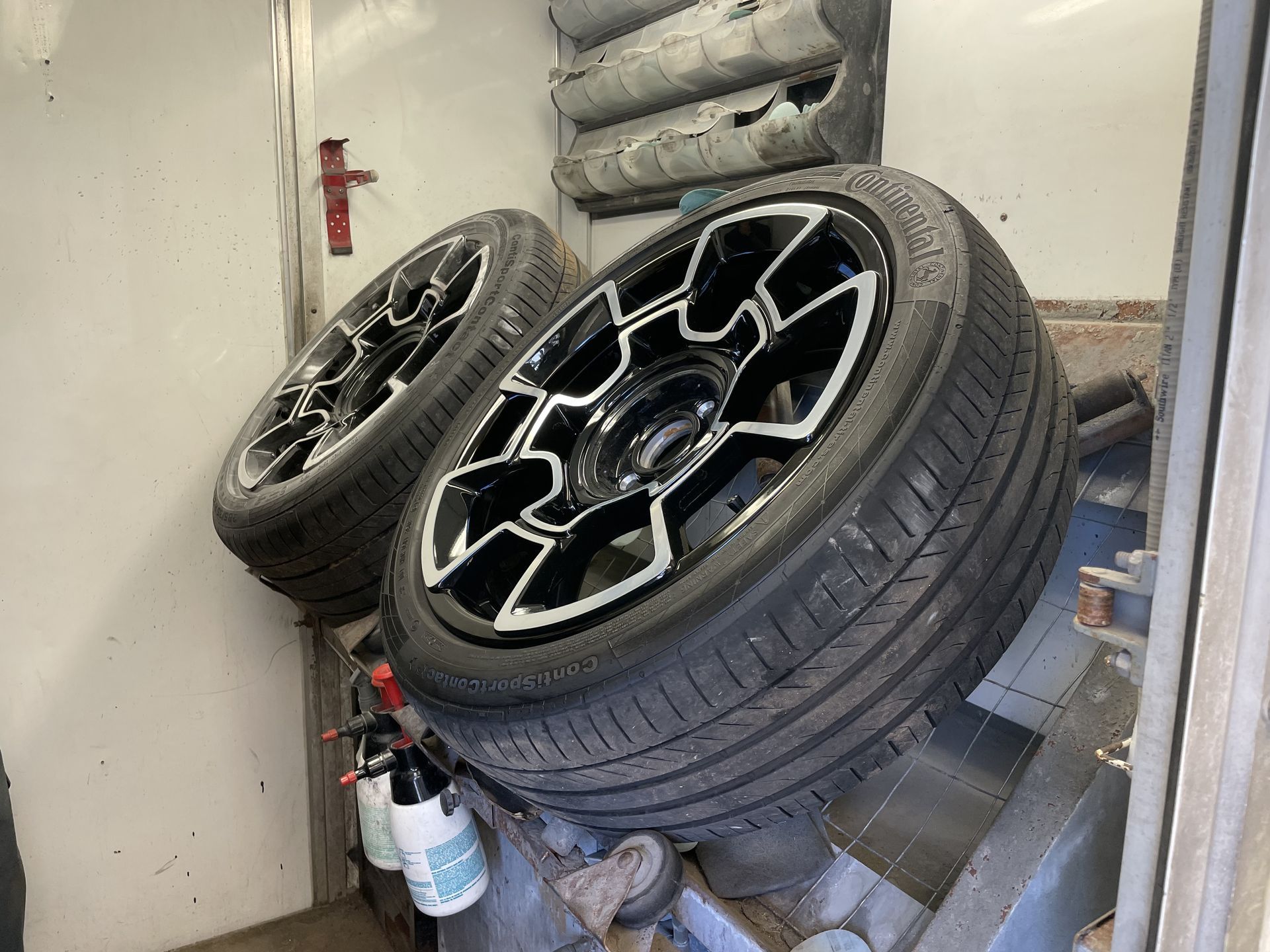 Two tires are sitting on top of each other in a garage.