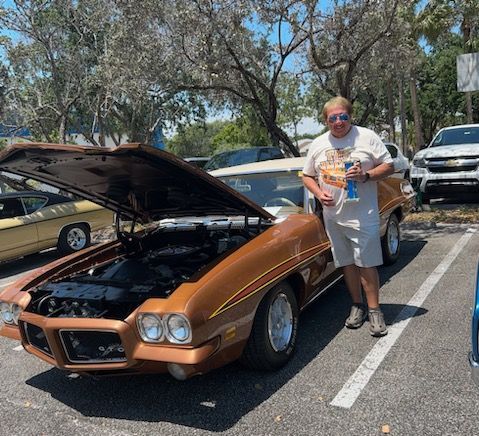 A man standing next to a car with the hood up