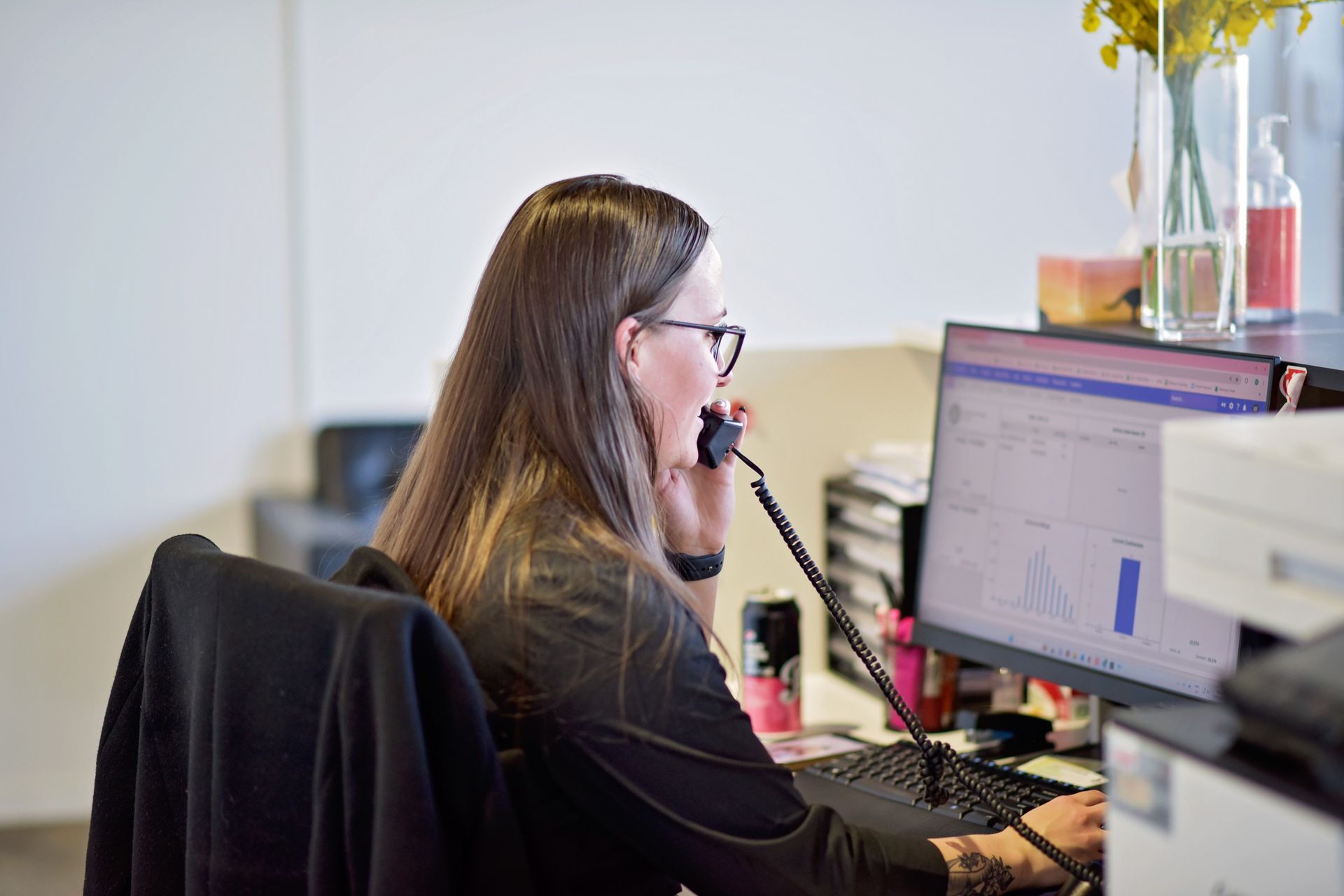 A man and a woman are standing next to each other in an office.