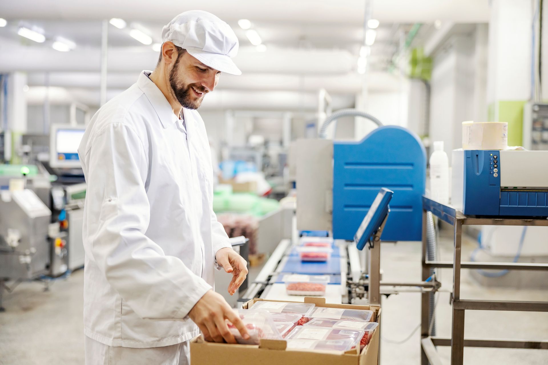 A man and a woman are standing in a warehouse looking at a tablet.