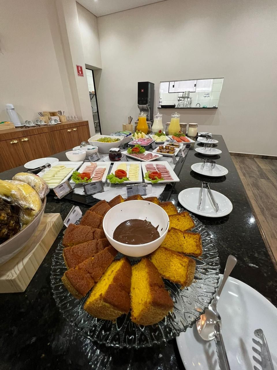 Uma mesa coberta com pratos de comida e uma tigela de calda de chocolate.
