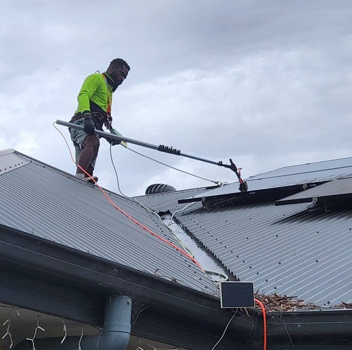 A Person is Cleaning a Roof — EDU-BABA Pressure Cleaning in Evatt, ACT