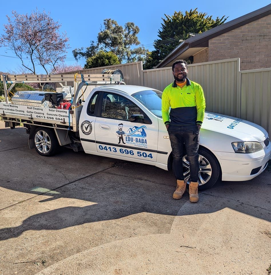 A Man is Cleaning a Wooden Deck — EDU-BABA Pressure Cleaning in Evatt, ACT