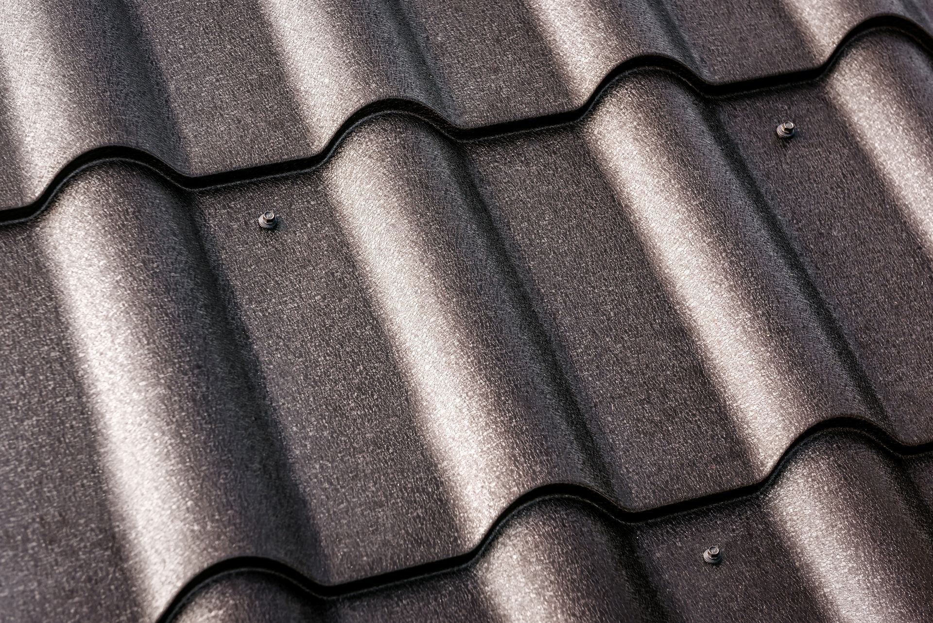 Close-up of a metallic brown, textured, corrugated roof, showing the pattern of the tiles.