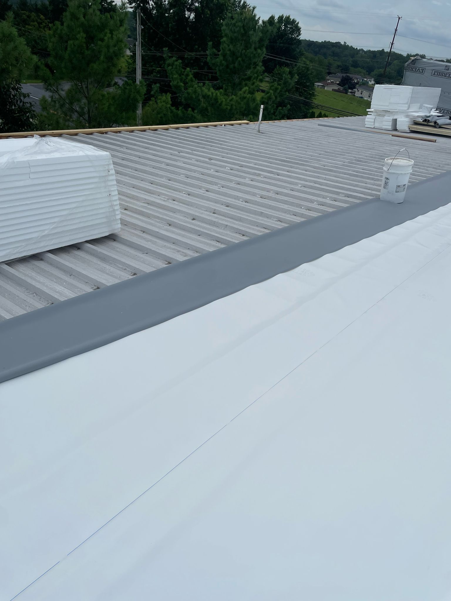 A silver corrugated metal roof with multiple ventilation domes. The angle of view is from above. A silver corrugated metal roof with multiple ventilation domes. The angle of view is from above.