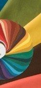 Colorful folded fabric fan with rainbow hues on a dark background
