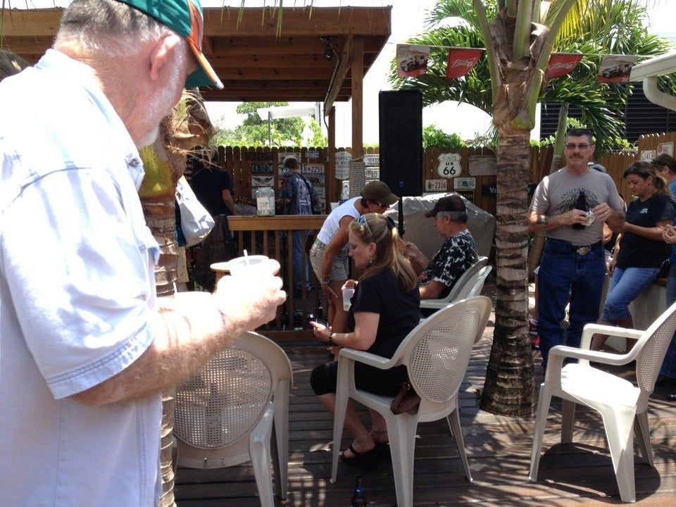 A man in a green hat stands in front of a group of people