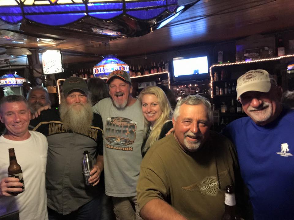 A group of people posing for a picture in a bar