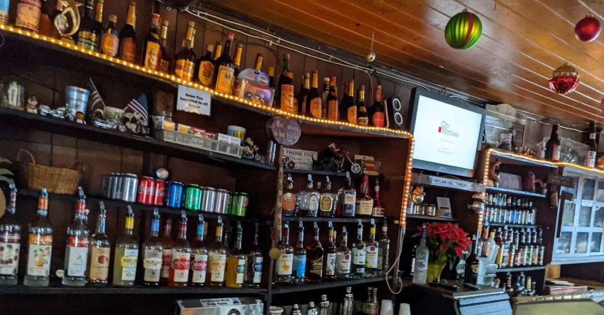 A bar with a lot of bottles on shelves