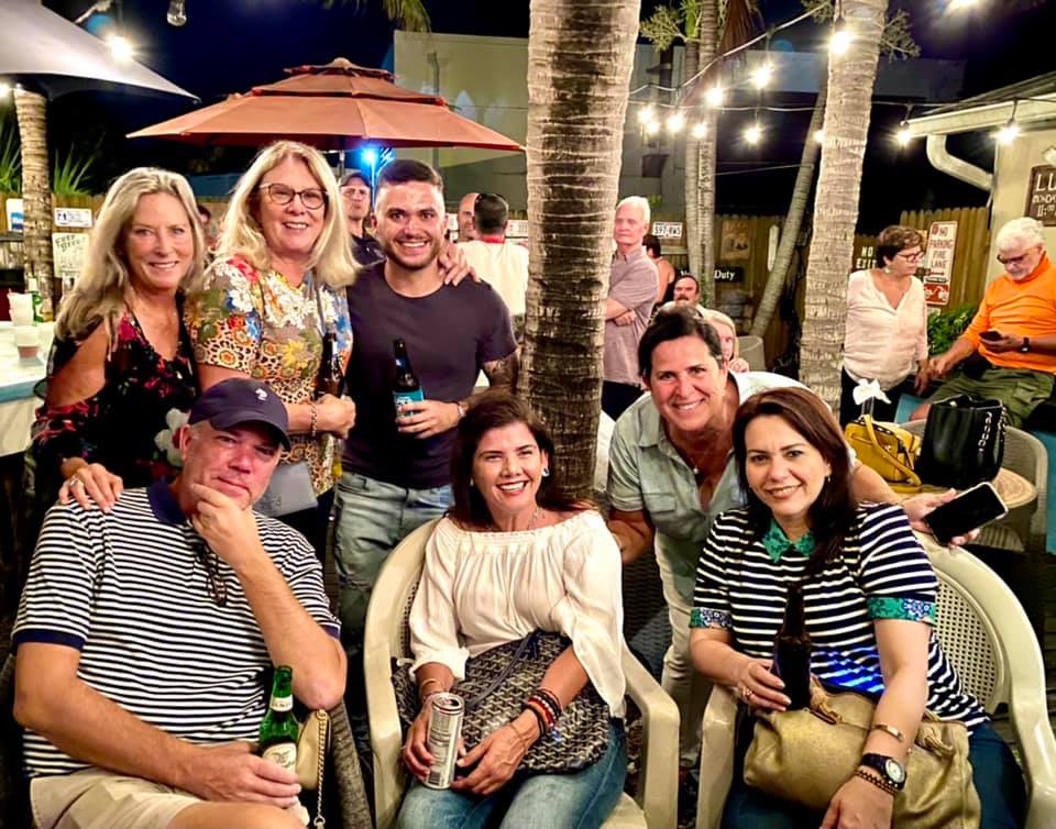 A group of people are posing for a picture under an umbrella