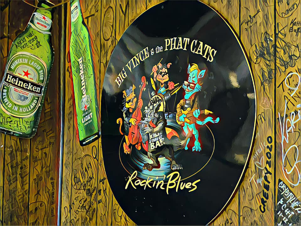 A bottle of heineken next to a sign that says rockin blues