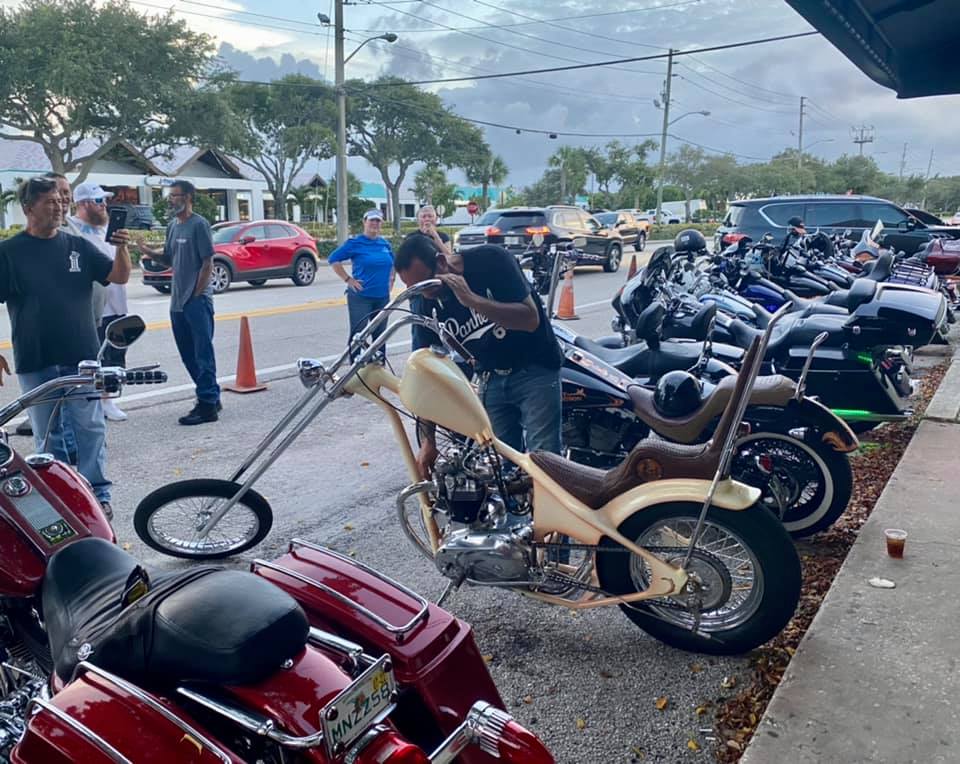 A row of motorcycles are parked on the side of the road