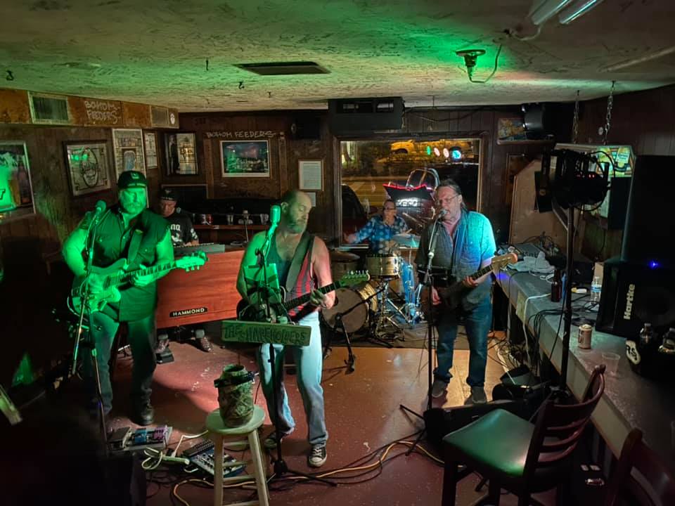A group of people playing instruments in a dark room