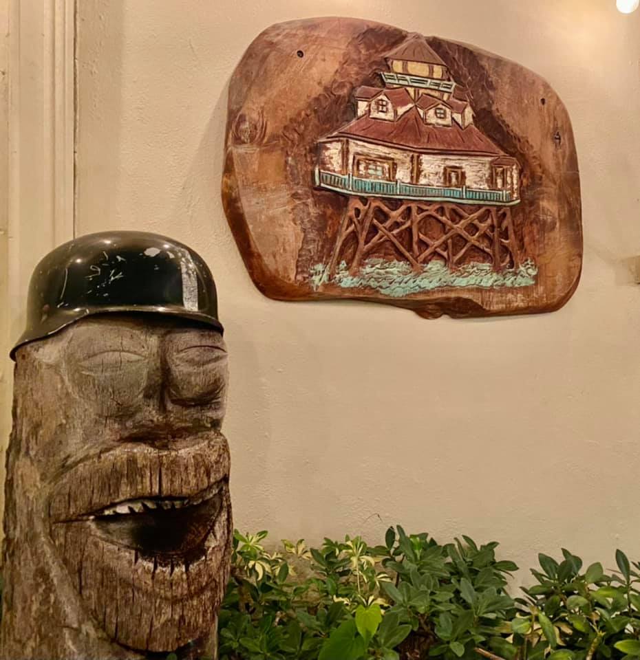 A wood carving of a man with a helmet on his head