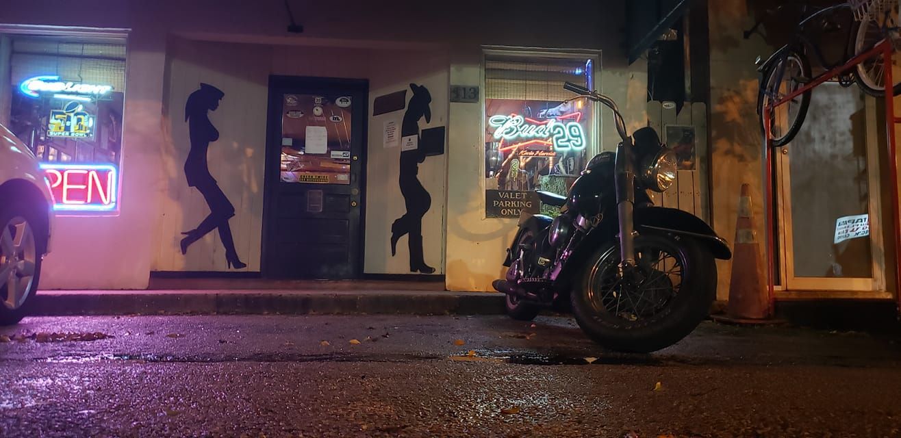 A motorcycle is parked in front of an open sign