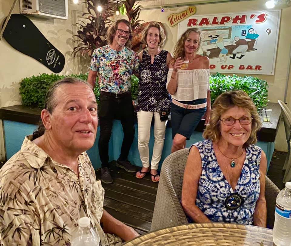 A group of people standing in front of a sign that says ralph 's