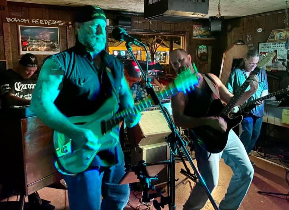 A man playing a guitar in front of a microphone