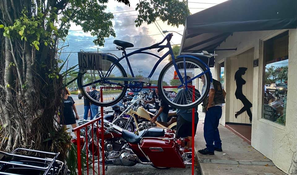 A bicycle is hanging on a rack outside of a building