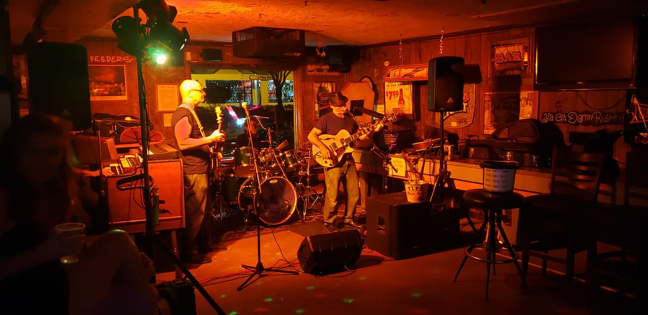 A group of people playing instruments in a dark room