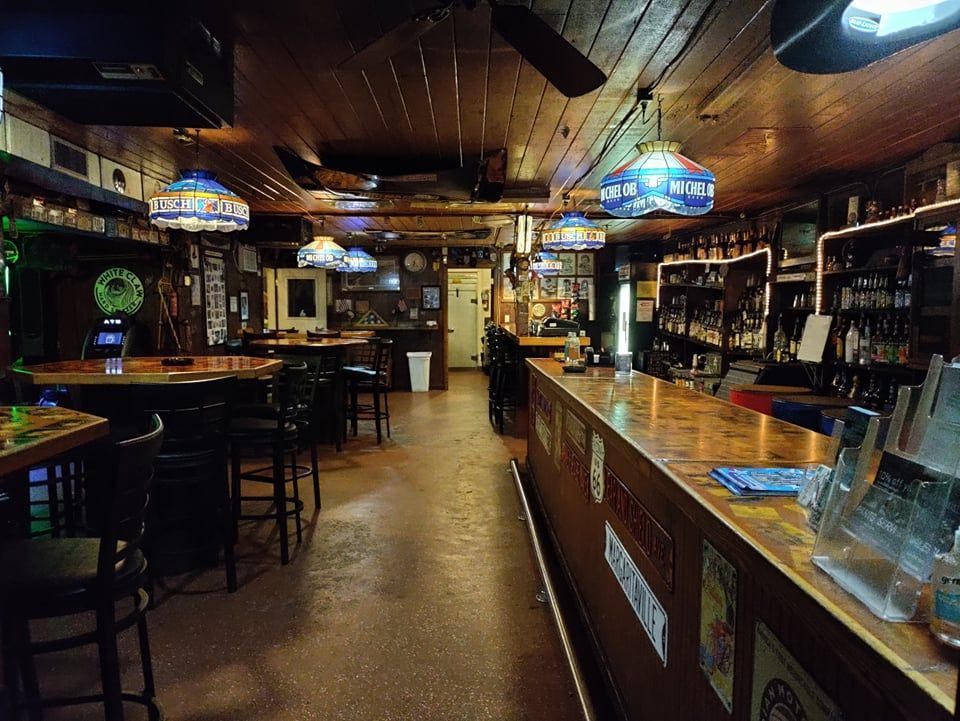The inside of a bar with tables and chairs
