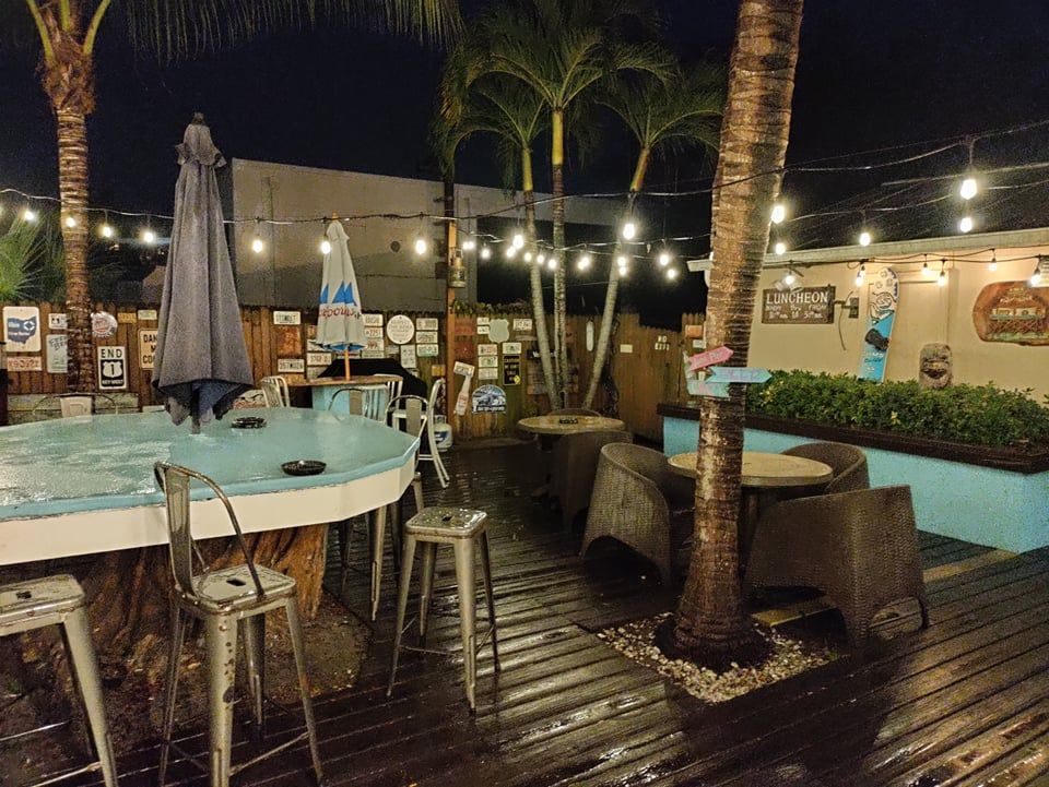 A patio area with tables chairs and umbrellas at night