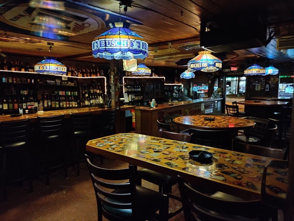 A bar with a sign on the ceiling that says bud light