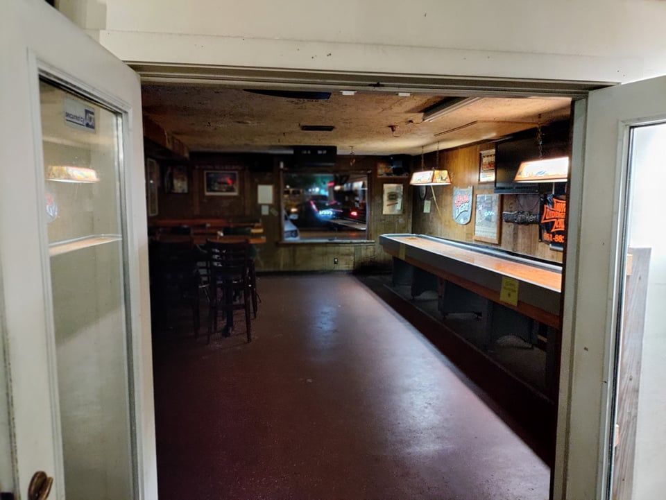 An empty room with a bar and tables in it
