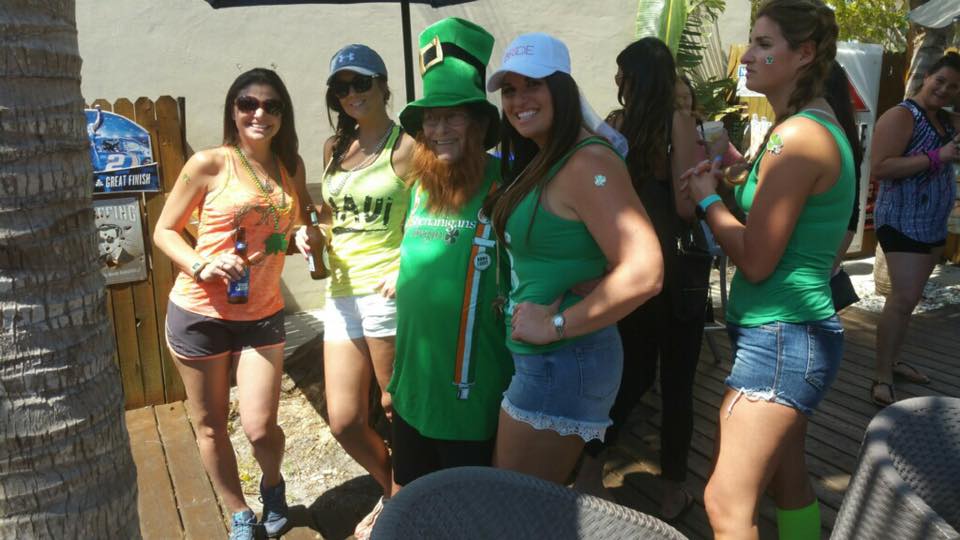 A group of women are posing for a picture in front of a palm tree