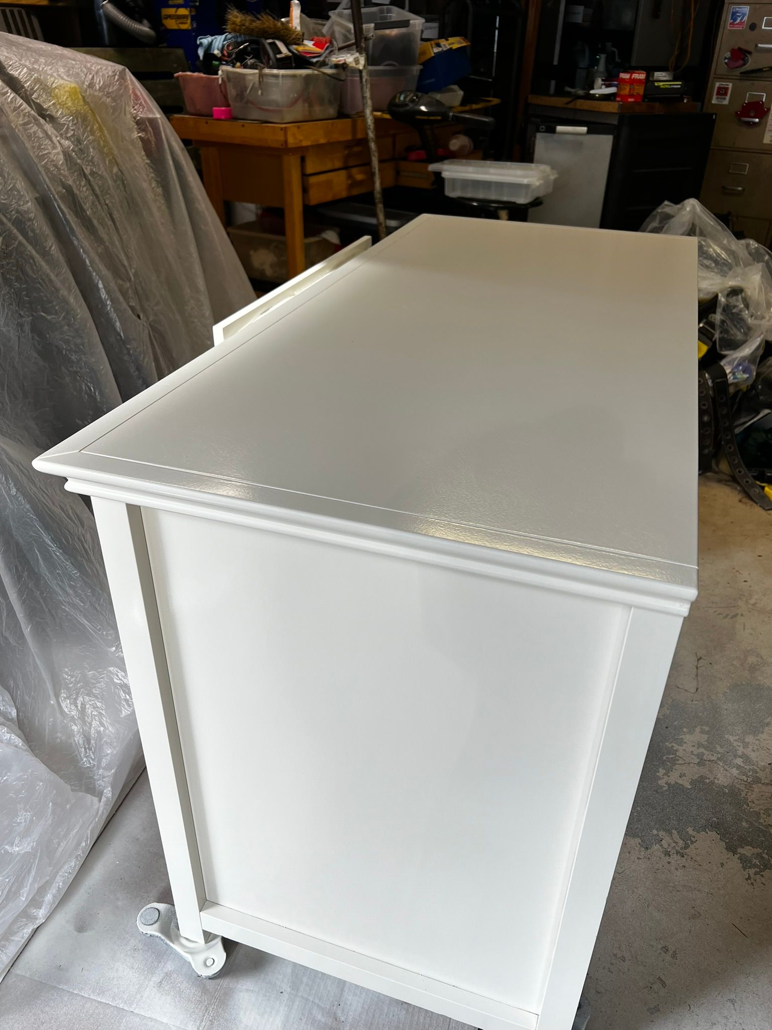 White cabinet, angled view, in workshop setting.
