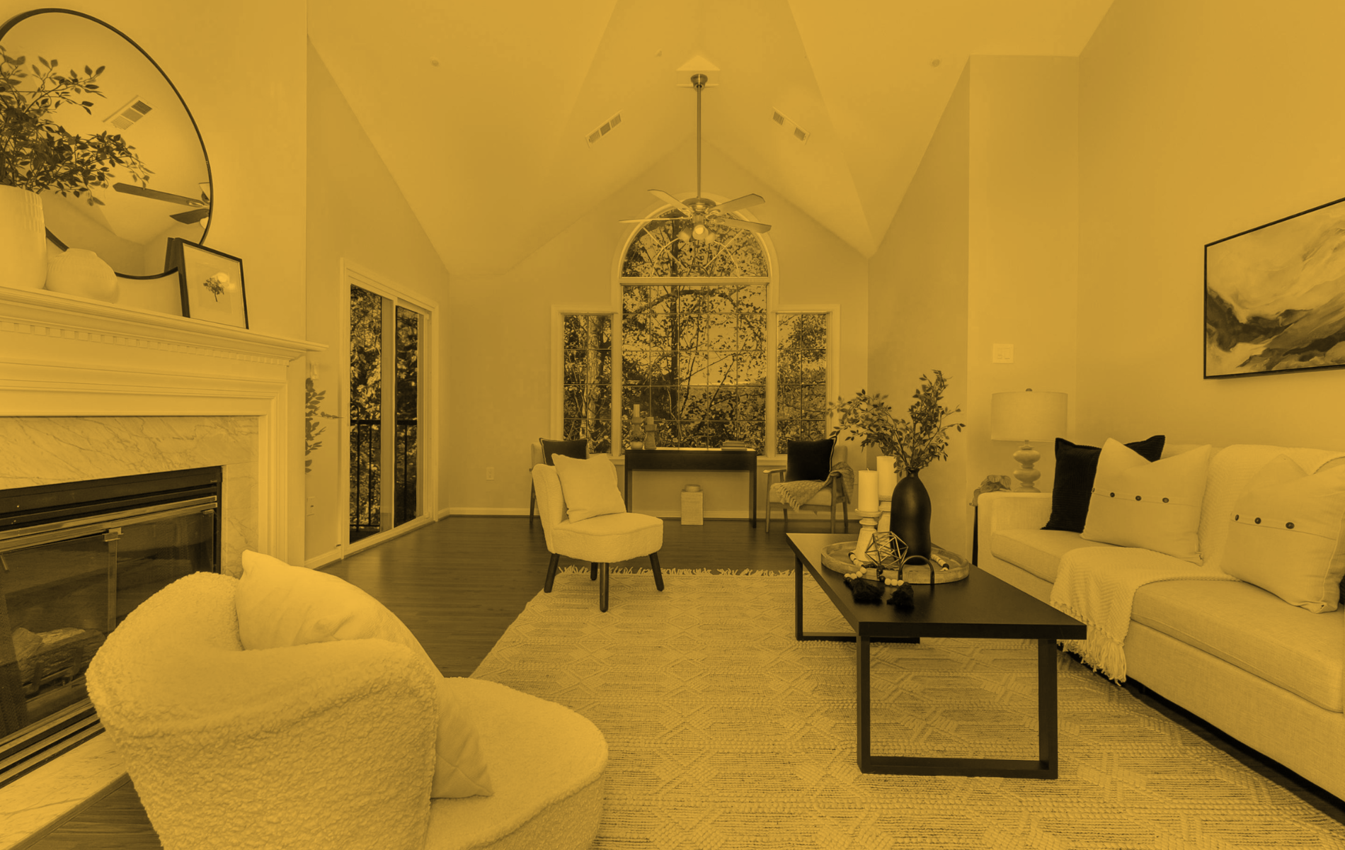 Living room with fireplace, arched window, white sofa, and neutral color scheme.