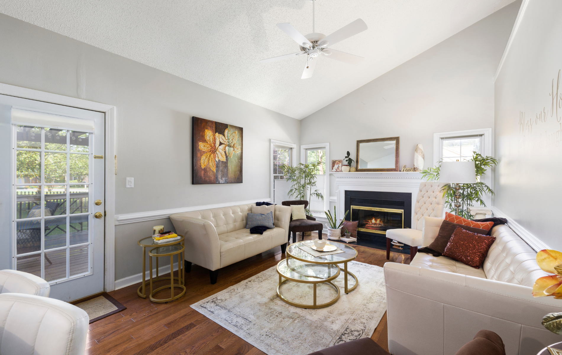 Living room with light gray walls, white furniture, fireplace, and natural light.