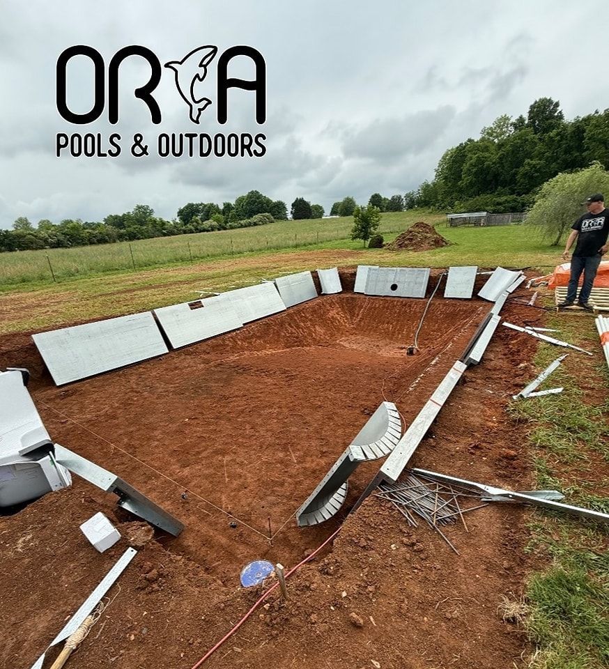 Pool installation, ORCA Pools & Outdoors logo. Metal pool frame in dirt, man standing, green field background.
