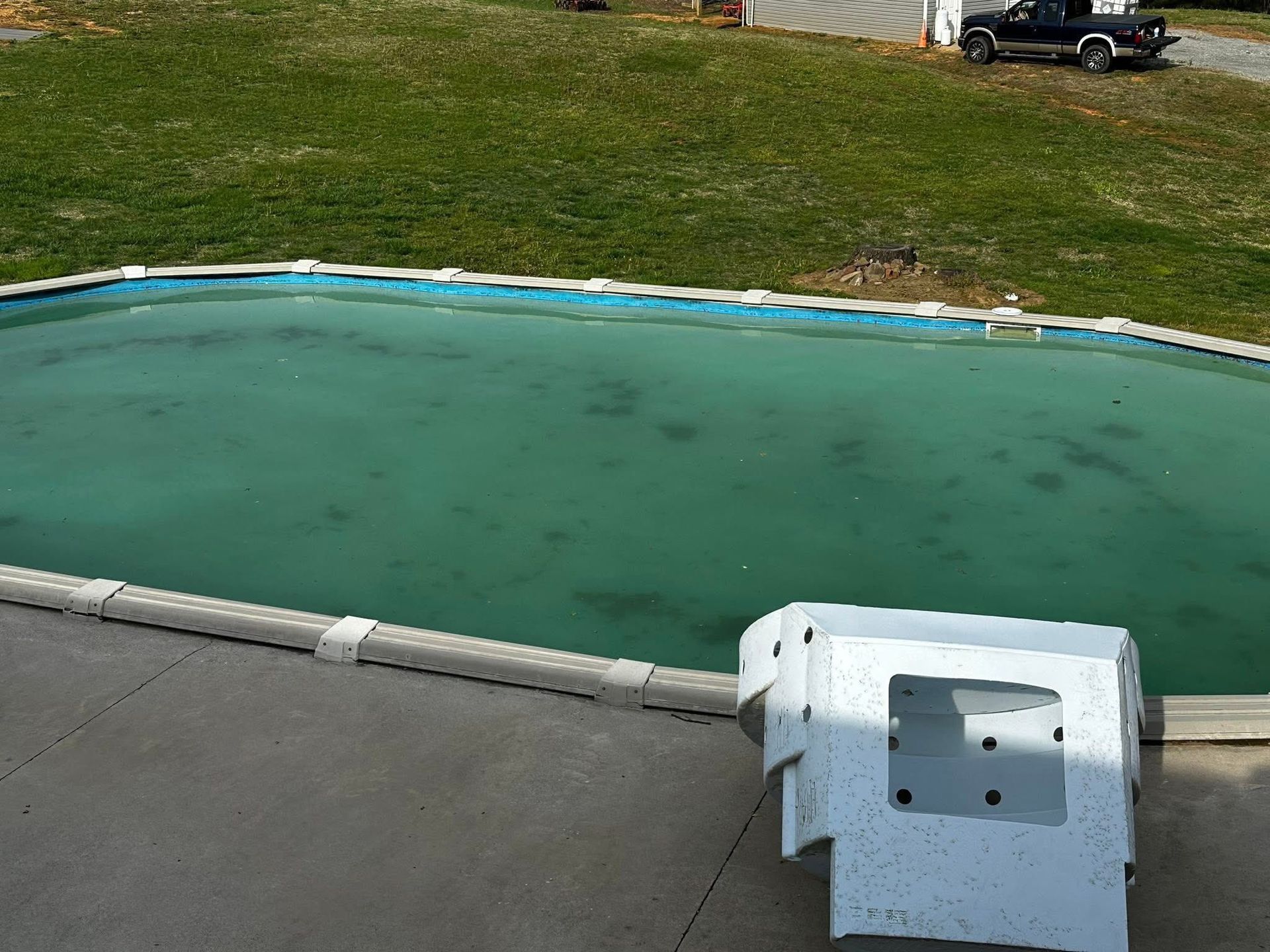 A swimming pool with a black truck in the background