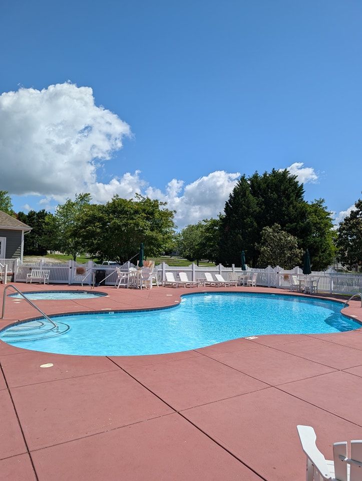 A large swimming pool with a white fence around it.