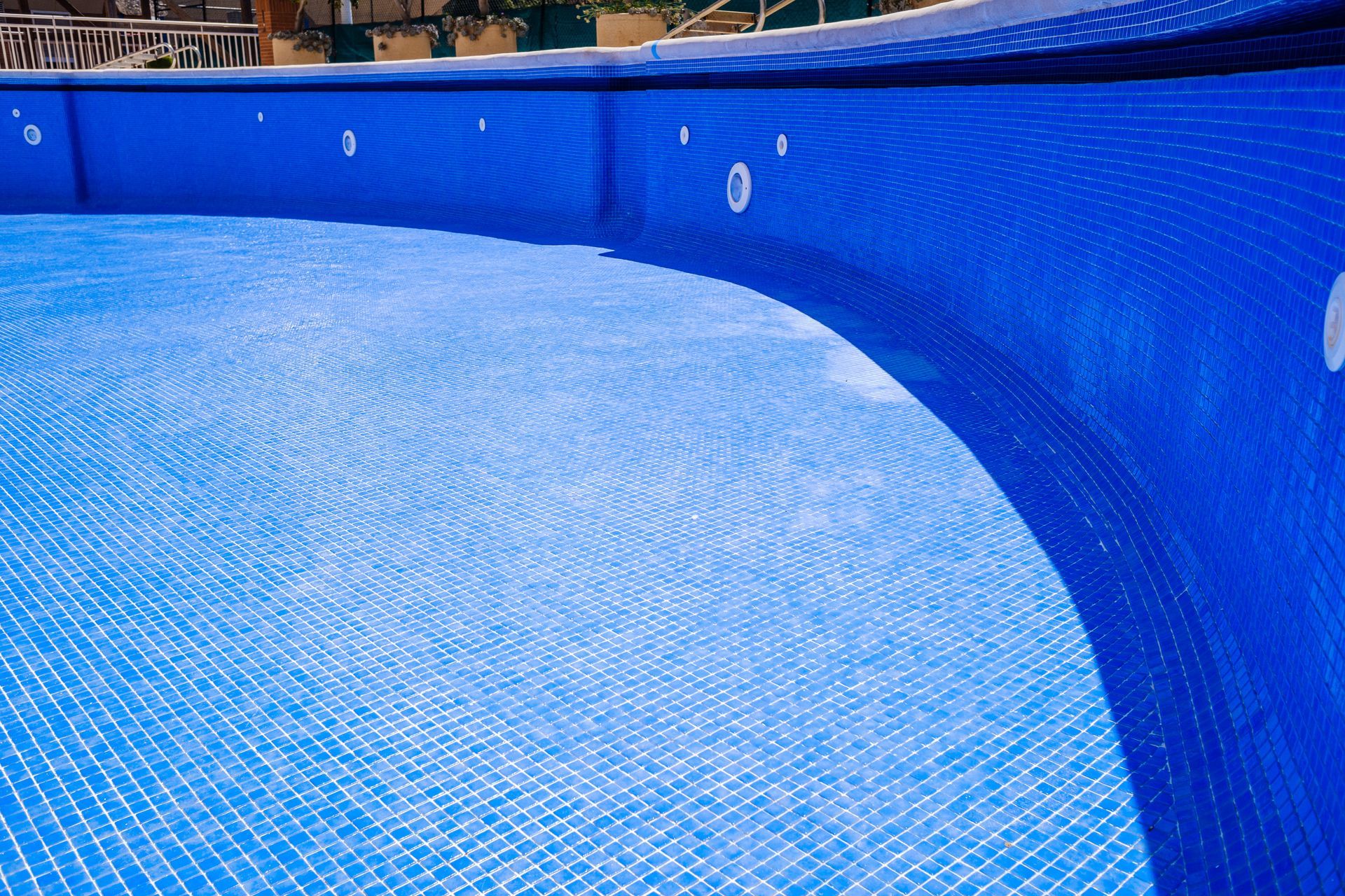 A large swimming pool with a blue tiled floor and walls.