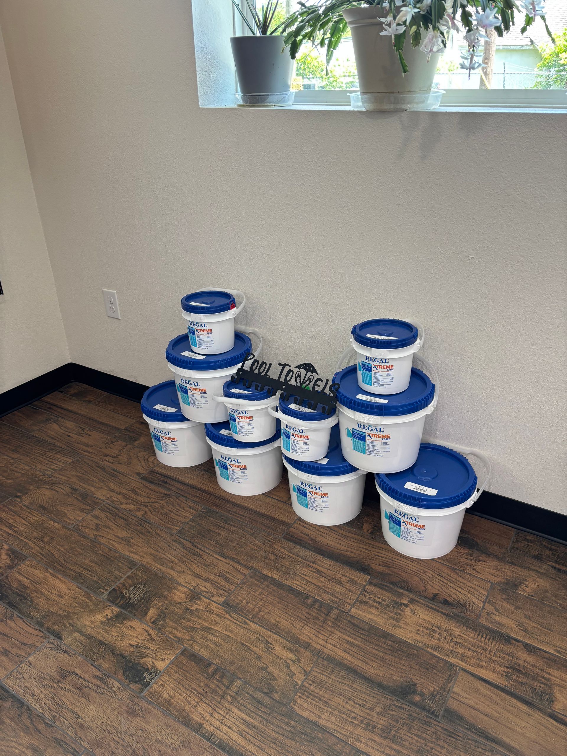 A bunch of buckets are stacked on top of each other on a wooden floor.