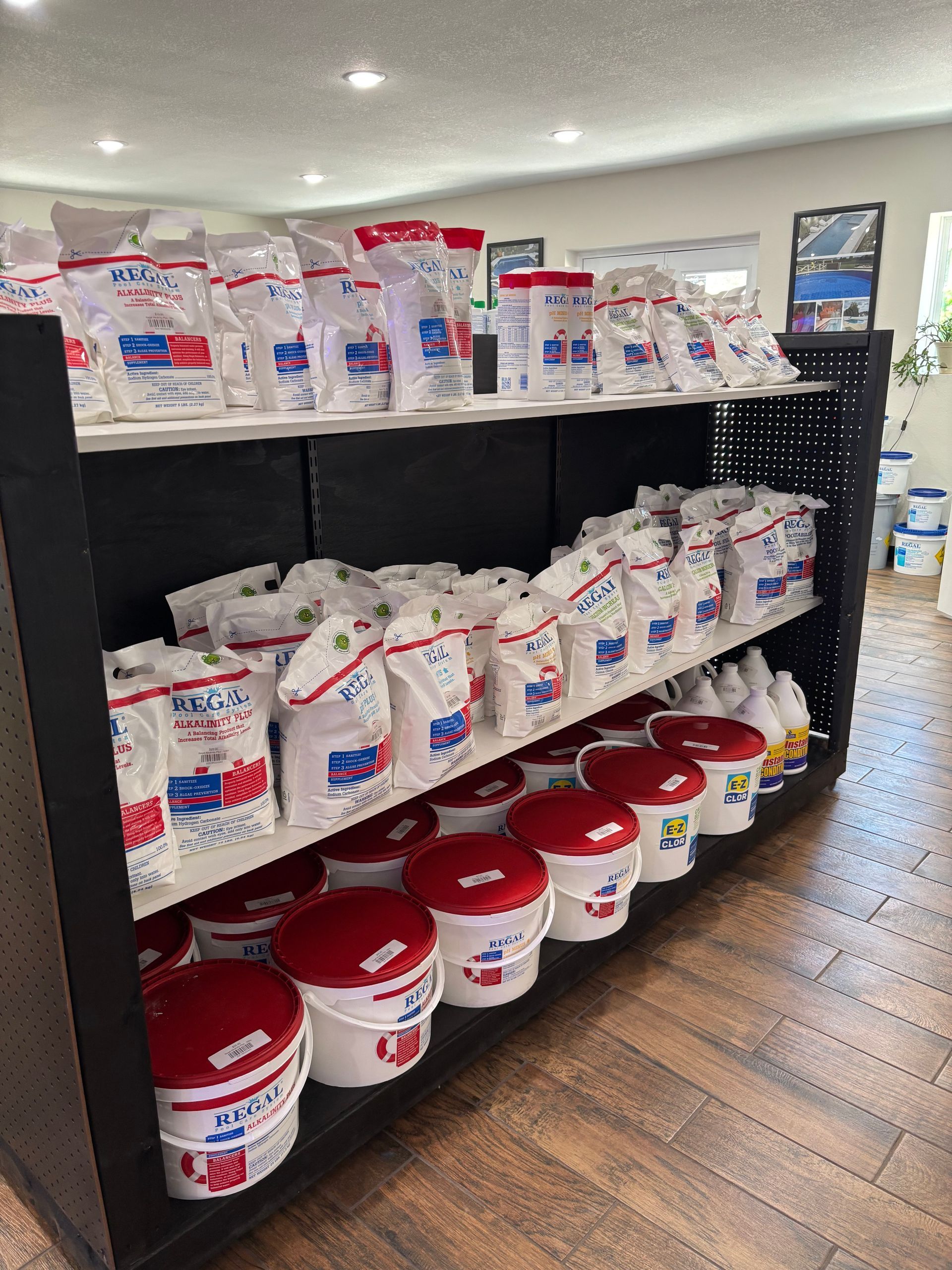 A shelf filled with buckets and bags of chemicals in a store.