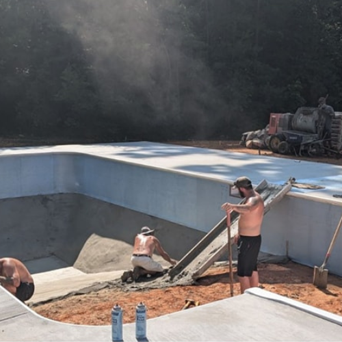 A group of men are working on a swimming pool