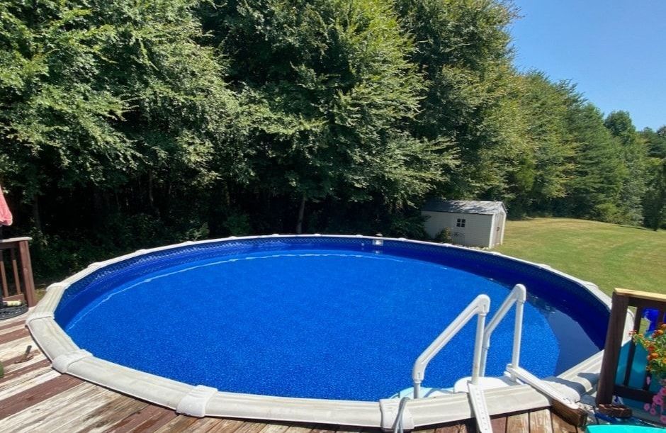 A round swimming pool is on a deck.