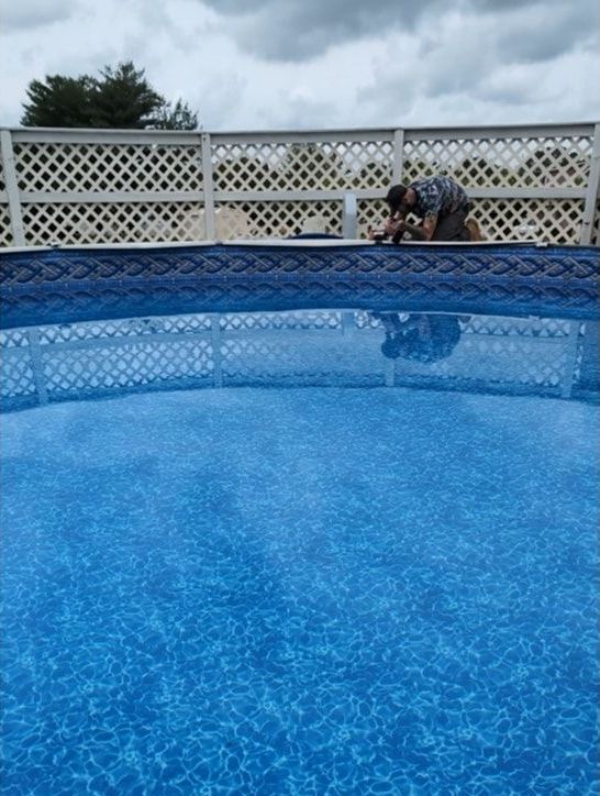 A man is working on a swimming pool on a cloudy day