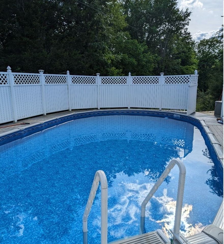 A large swimming pool with a white fence around it
