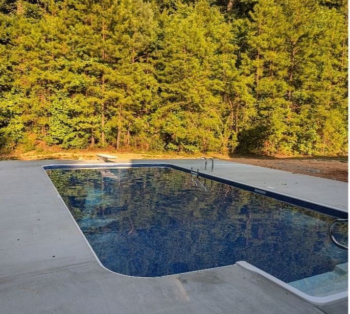 A large swimming pool with trees in the background